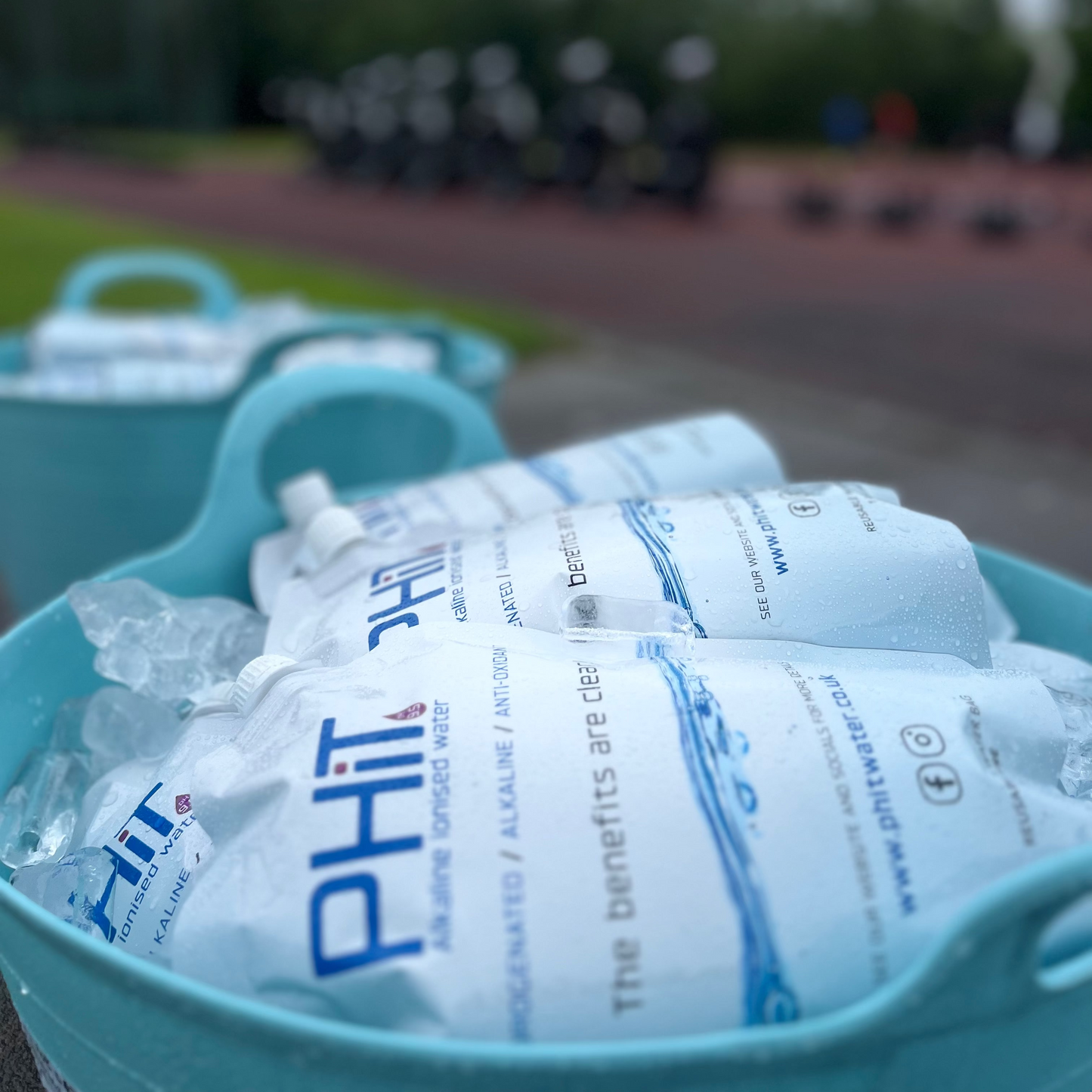 Ice packs labeled 'PHit' in a blue container with a blurred outdoor background